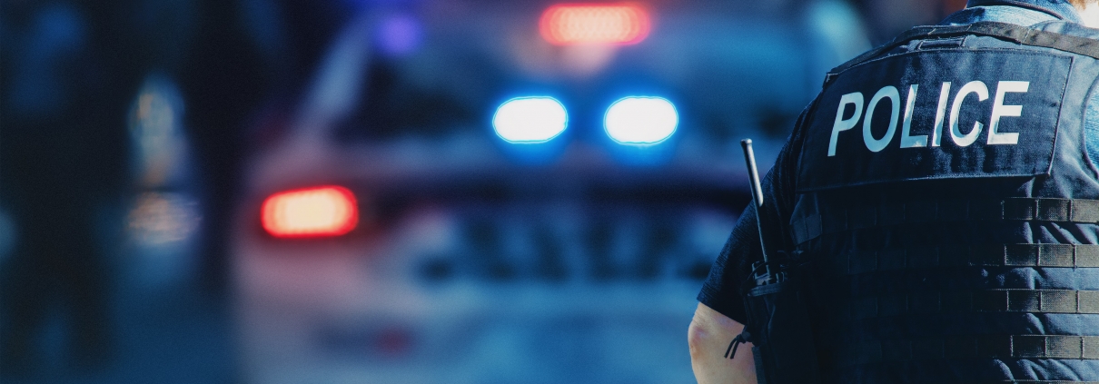 Police officer standing in front of a patrol car