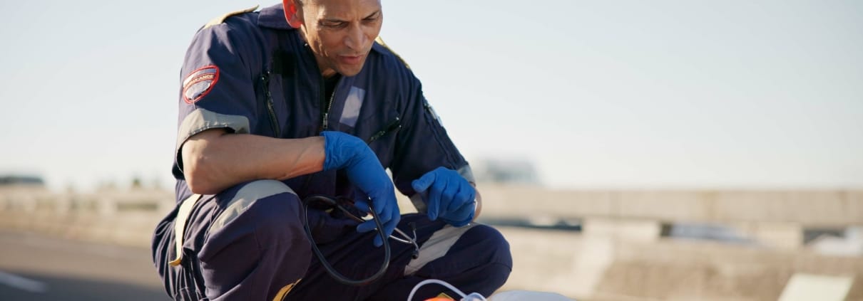 EMS professional speaking with a stabilized car crash victim