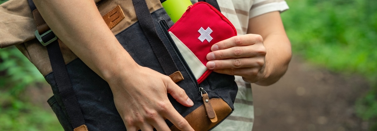 Close up of a man packing a first aid kit outside
